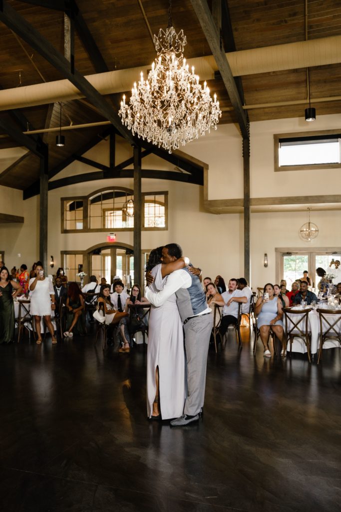 the groom and his mom hug during their dance while michigan wedding photographer captures his reception