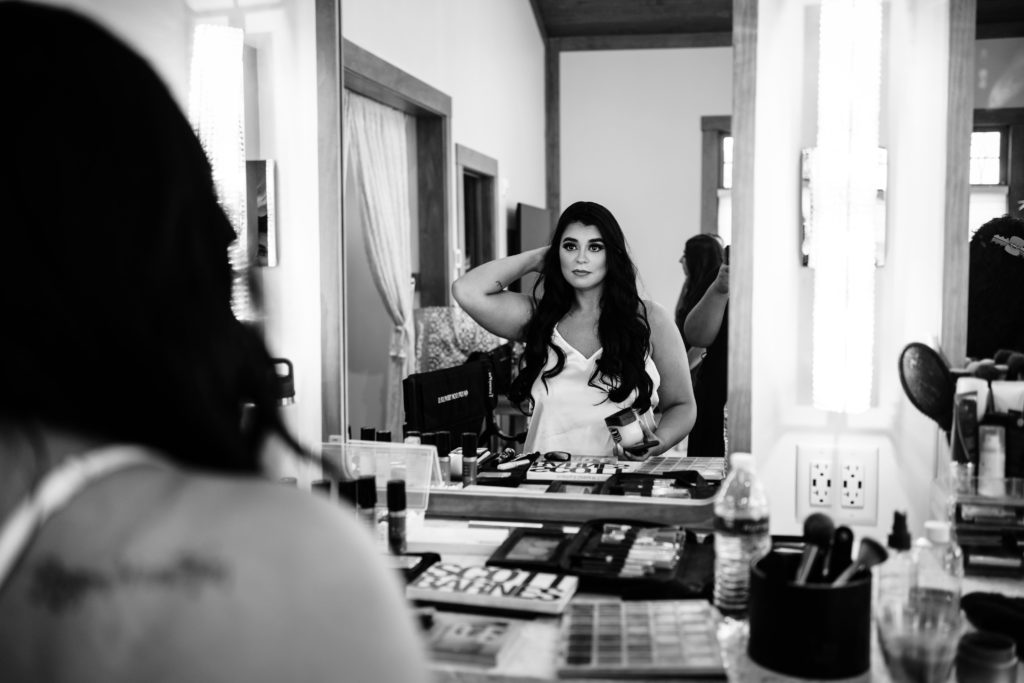 luxury wedding photographer captures the bride's reflection in the mirror while getting ready