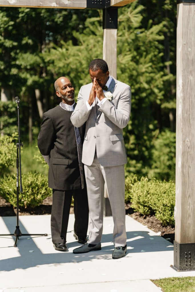 michigan wedding photographer captures the groom getting emotional after seeing the bride begin to walk toward him