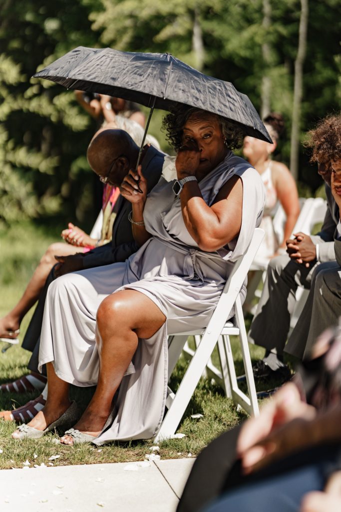 michigan wedding photographer captures a guest as they wipe a tear at an emotional wedding