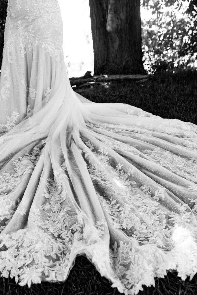 a photo by luxury wedding photographer documenting the details of the bride's dress and train