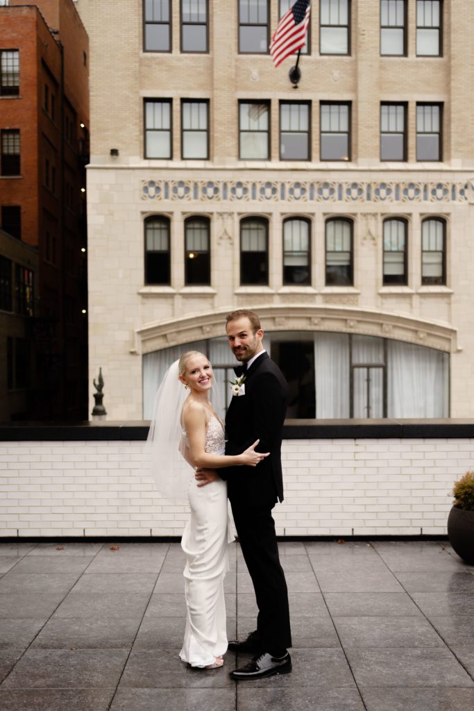 the bride and groom stand together on the roof of their shinola hotel wedding