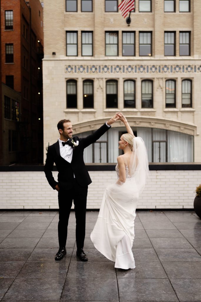 the bride and groom share a dance on the roof with their detroit wedding photographer