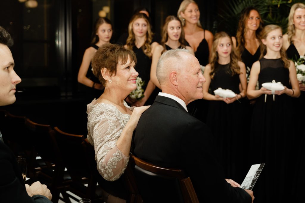 parents of the newlyweds gaze at the two during the ceremony and are captured by a metro detroit wedding photographers