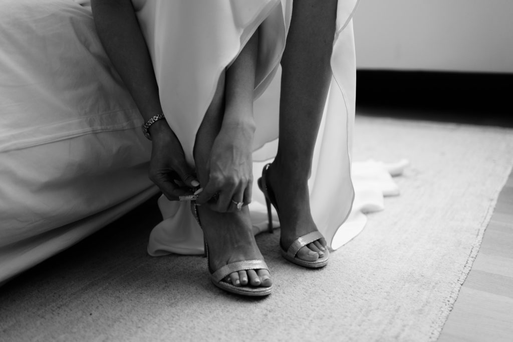the bride slips into her heels before the big day with details taken by a detroit wedding photographer