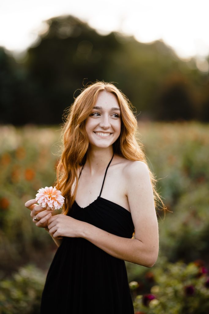 louise smiles while holding a flower during her senior pictures ann arbor