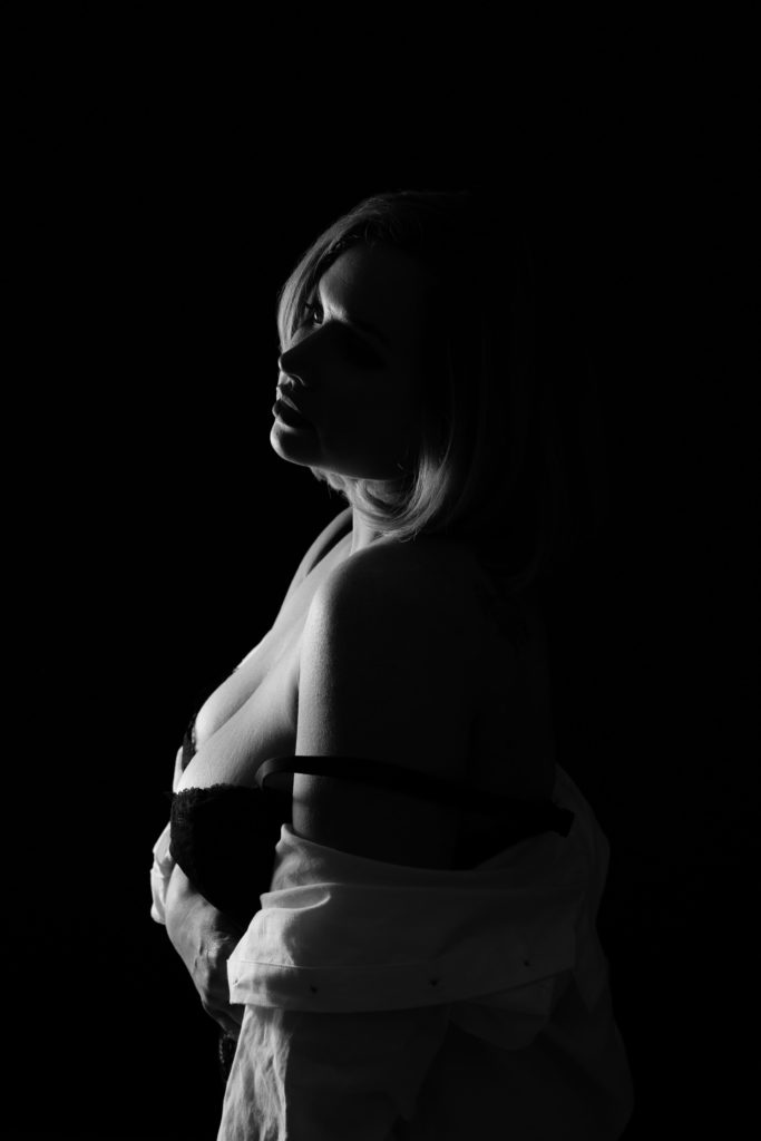 (ann arbor michigan) jo stands in dramatic lighting during a session for boudoir photography near me
