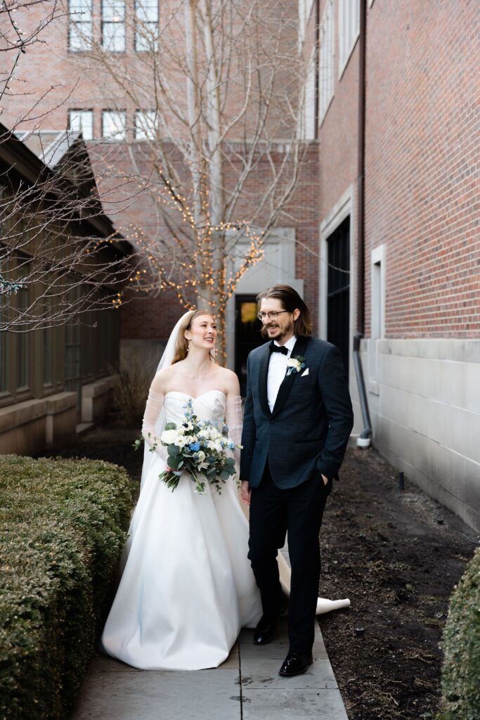 the bride and groom smile while walking the grounds of their royal park hotel wedding in michigan