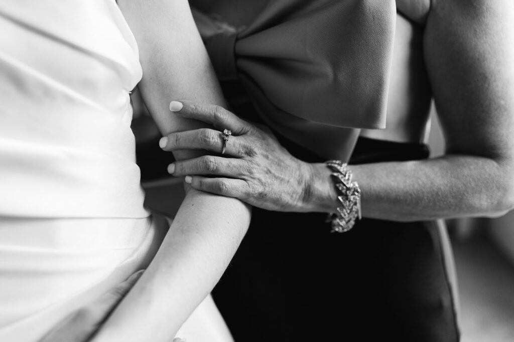 the bride's mother gently rests her hand on the bride's arm