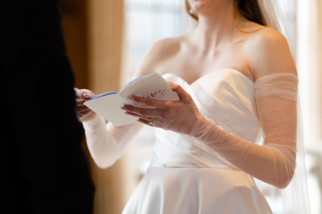 the bride holds a vow book while sharing private vows with the groom before their royal park hotel wedding ceremony
