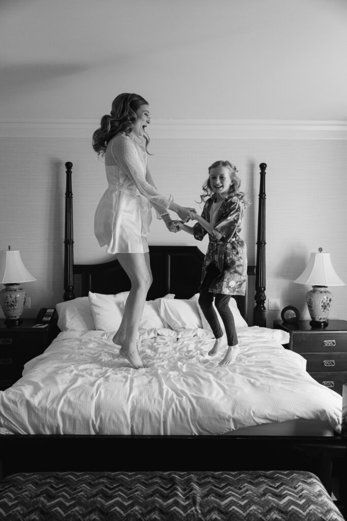 the bride jumps on the bed with a flower girl