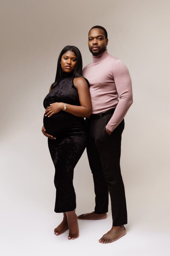 camille and david look fiercely at the camera during a studio maternity photoshoot
