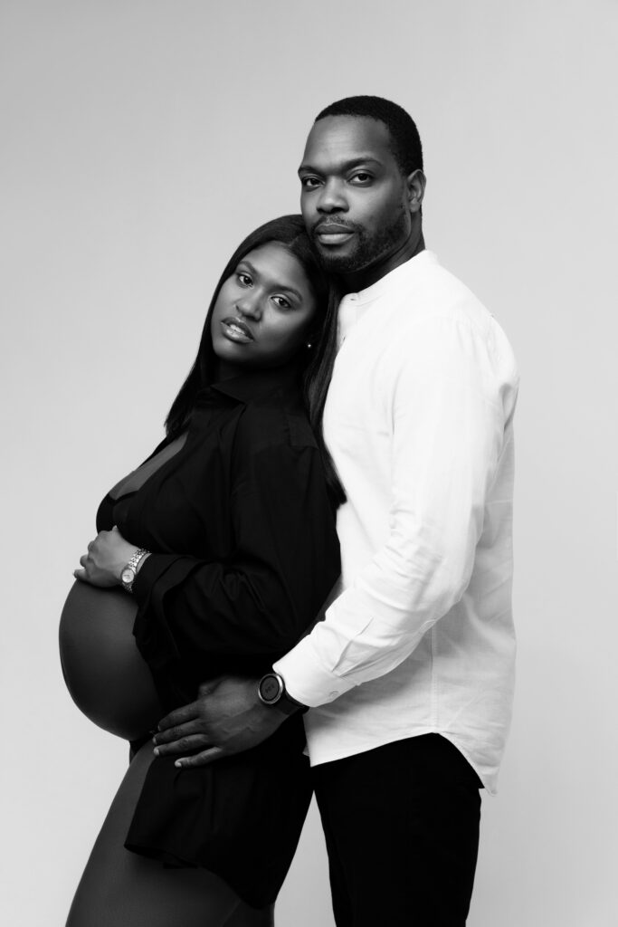 camille and david look at the camera during their studio maternity photos
