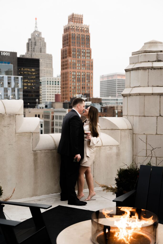 jane and john share a kiss my the fire on a detroit rooftop