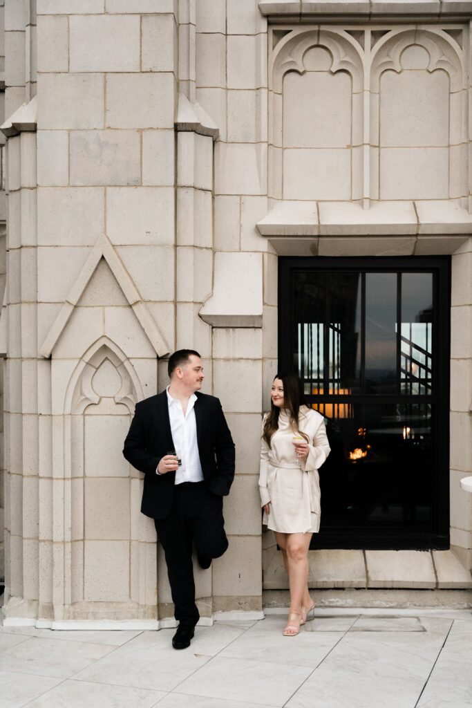 jane and john smile at each other during their downtown detroit engagement photos