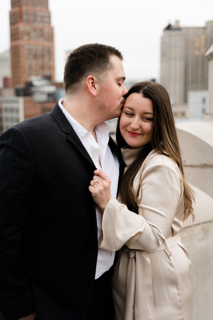 john presses a kiss to the top of jane's head during their detroit engagement photos