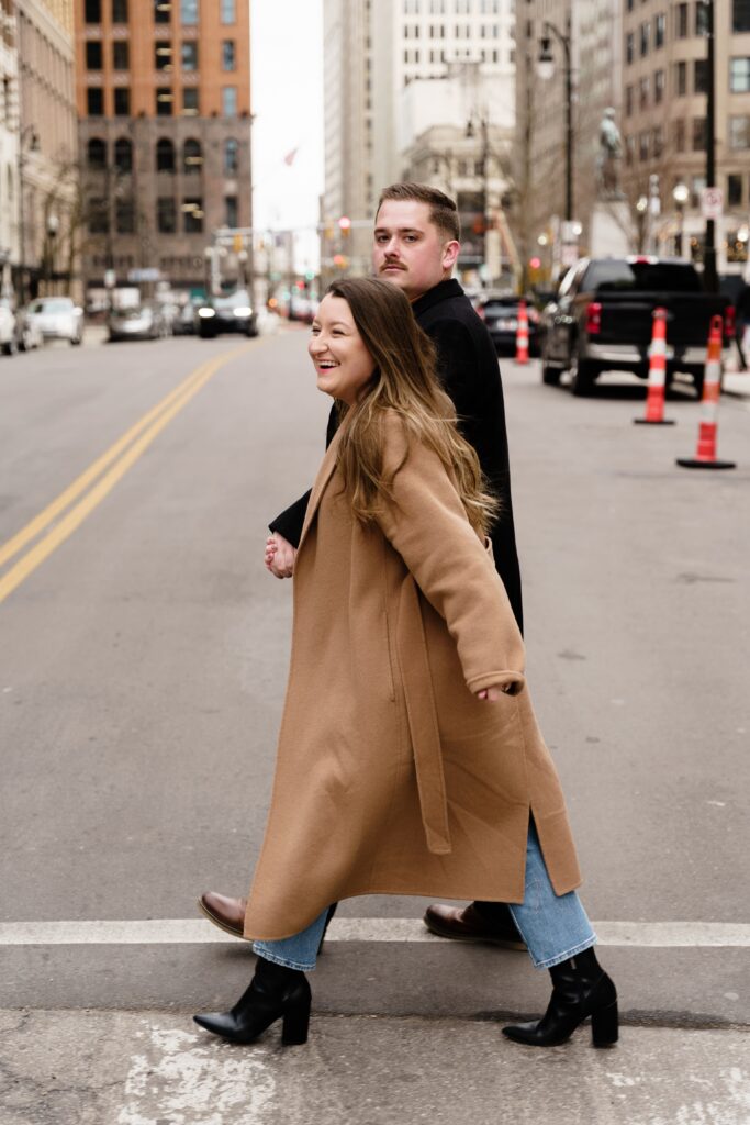 jane smiles while crossing the street with john
