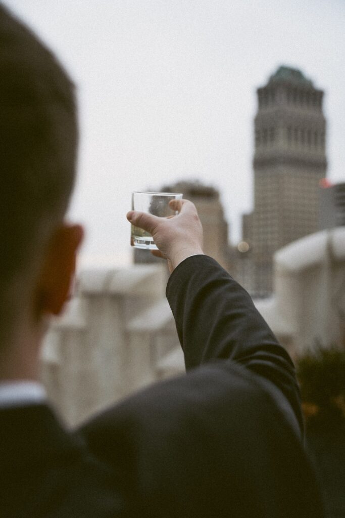 john lifts his drink to cheers the detroit skyline