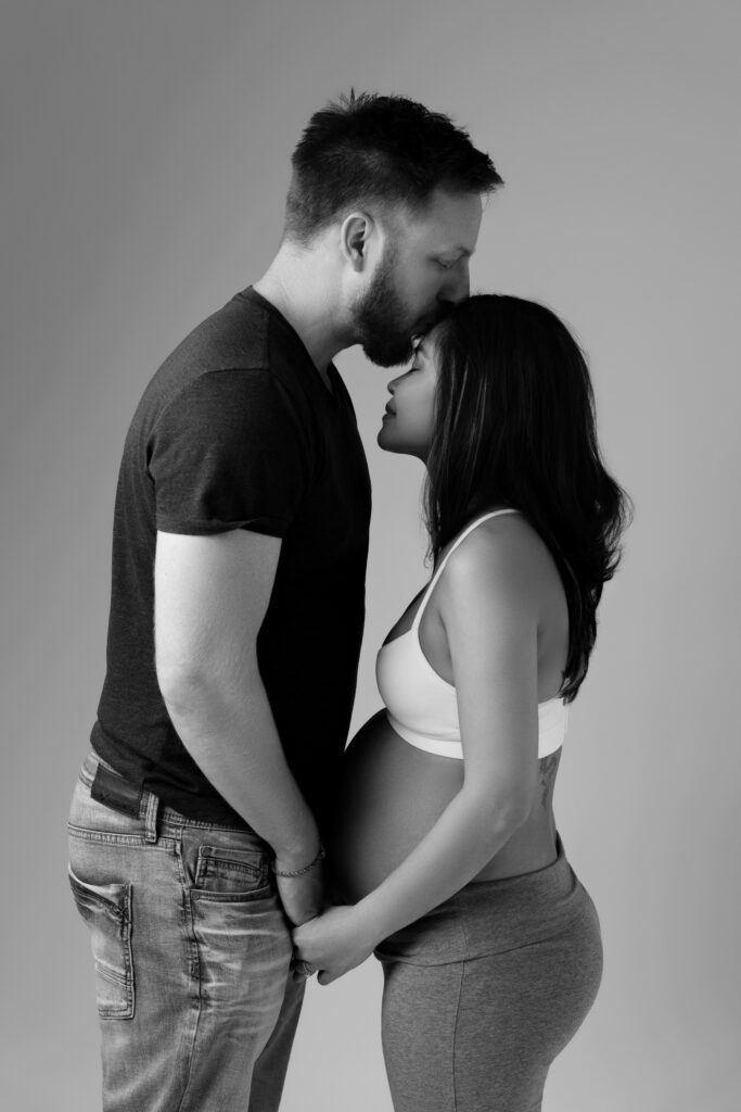 andy kisses nat's forehead during their lifestyle maternity photos