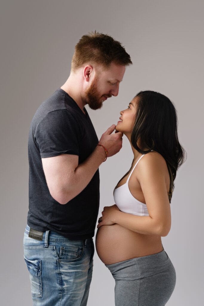nat and andy smile at each other during their lifestyle maternity photos