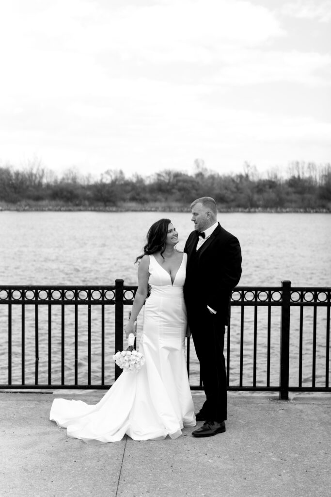 the bride and groom look at each other waterfront during portraits with their michigan elopement photographer