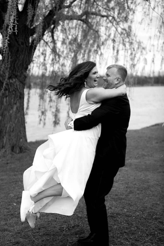 the bride and groom laugh as he swings her around during bridal portraits
