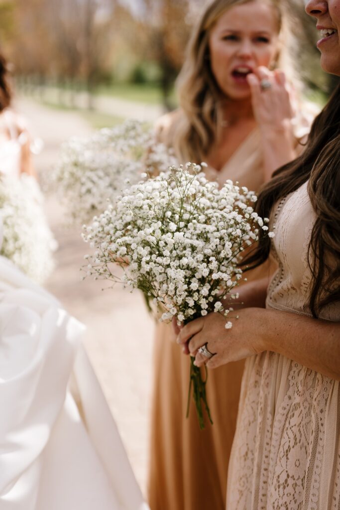 a bridesmaid holds a bouquet of baby's breath at an intimate elopement