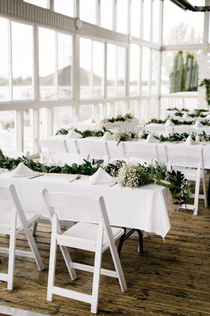 four tables are set with greenery and white napkins at an intimate elopement