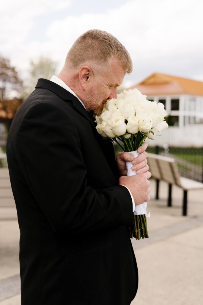 the groom sniffs the bride's bouquet