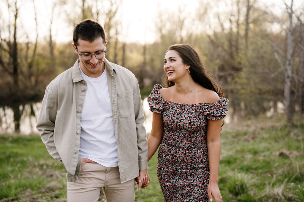 spencer and dalia laugh together with their michigan engagement photographer at matthaei botanical gardens