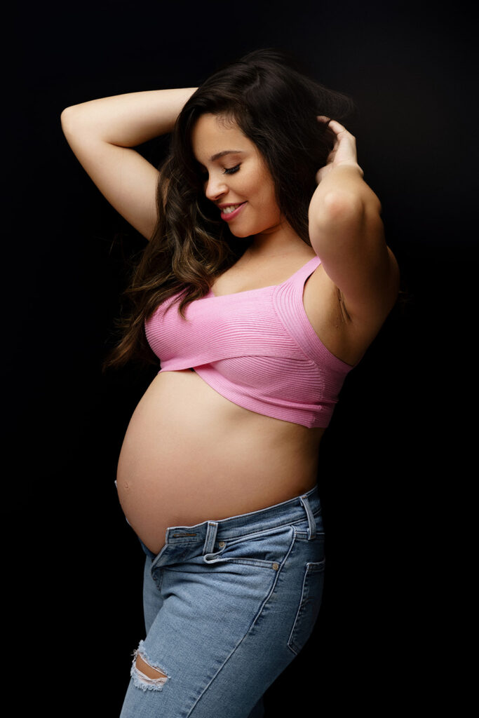 pregnant woman wearing jeans and pink top