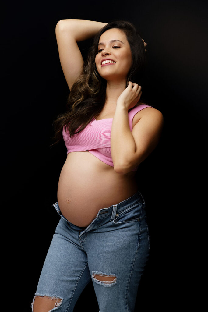 pregnant woman posing jeans and pink top
